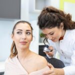 Dermatólogos - Mujer en consulta dermatológica con uno de las mejores dermatólogos en Sevilla