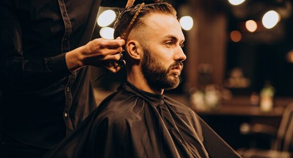 Barberías - Barbero de una peluquería barbería cortando el cabello de un hombre en una de las mejores barberías en Sevilla