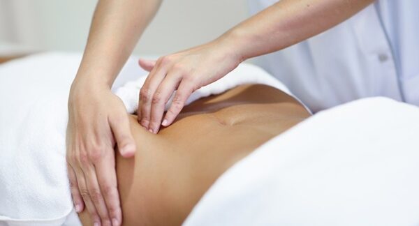 Cirujanos abdominales - Médico abdominal reconocido como uno de los mejores cirujanos abdominales de Sevilla evaluando a una mujer con enfermedades abdominales