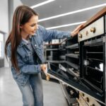 Tiendas de electrodomésticos - Mujer observando aparatos eléctricos y utensilios del hogar en una de las mejores tiendas de electrodomésticos en Sevilla