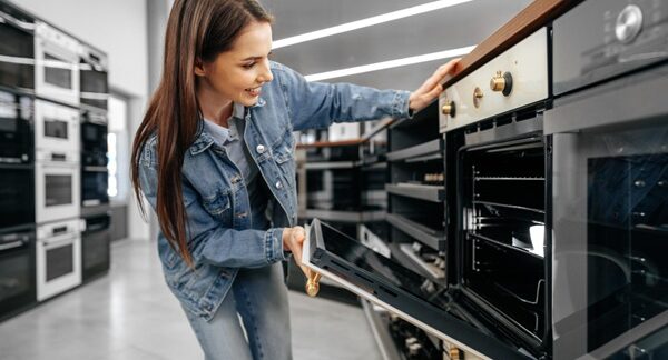 Tiendas de electrodomésticos - Mujer observando aparatos eléctricos y utensilios del hogar en una de las mejores tiendas de electrodomésticos en Sevilla