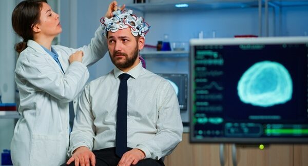 Centros para el dolor de cabeza - Neurólogo evaluando a un hombre con dolor de cabeza por migraña o cefalea en uno de los mejores centros para el dolor de cabeza en Sevilla