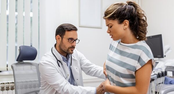 Proctólogos - Médico proctólogo reconocido como uno de los mejores proctólogos de Sevilla evaluando a una mujer en consulta de proctología por problemas en el colon