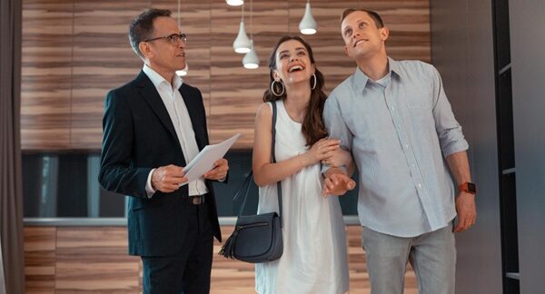 Agencias inmobiliarias - Asesora de inmobiliaria mostrando casas en venta a personas que buscan la compra o el alquiler de propiedades en Sevilla