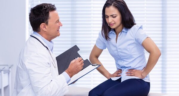 Especialistas del sistema digestivo - Mujer en consulta de gastroenterología siendo evaluada por un médico aparato digestivo reconocido como el mejor gastroenterólogo en Sevilla