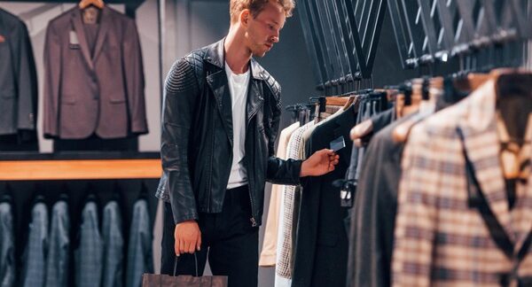 Ropa para hombre - Hombre en una tienda para caballero observando las prendas para comprar ropa en una de las mejores tiendas de ropa para hombre de Sevilla