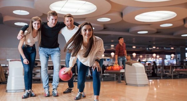 Clubes de bolos - Personas en una pista de boliche jugando bowling en uno de los mejores clubes de bolos de Sevilla