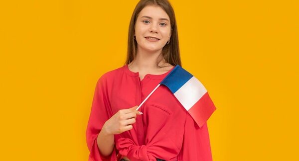 Escuelas de francés - Estudiante de un curso de francés sosteniendo una bandera de Francia en las clases de francés de las mejores academias de francés en Sevilla