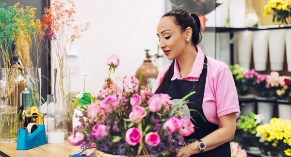 Floristerías - Mujer experta en arreglos florales armando un ramo de flores en una de las mejores floristerías de Sevilla