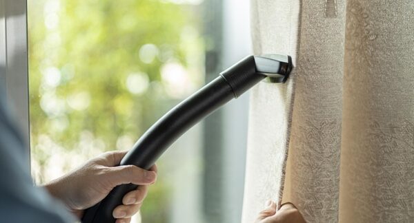 Servicios de lavado de cortinas - Personal de una de las mejores empresas de servicios de lavado de cortinas en Sevilla realizando el mantenimiento de cortinas a domicilio
