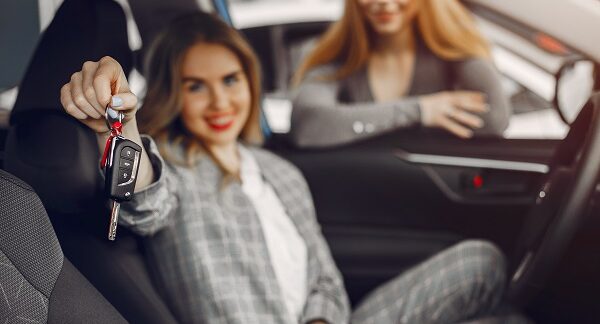 de las mejores marcas de coches, una mujer sostiene la llaves de un coche dispuesta a probarlo, mientras la vendedora observa
