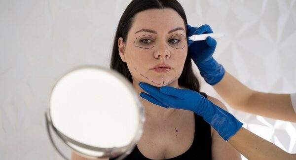 en un de las clínicas de lifting facial, una especialista marca las zonas de la cara de una paciente femenina, lista para realizar este procedimiento
