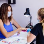 en uno de los salones de uñas, una mujer se hace arreglos en las uñas con una especialista