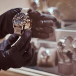 tiendas de relojes - un relojero con guantes exhibe un reloj lujoso