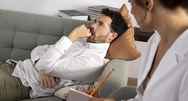 tratamiento de la ansiedad - un hombre recostado en un mueble recibiendo terapia psicológica