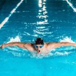 mejores escuelas de natación - un hombre nada en estilo mariposa