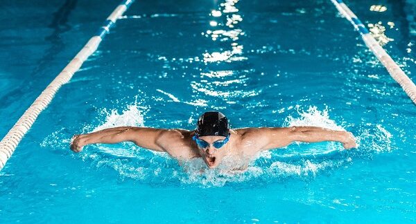 mejores escuelas de natación - un hombre nada en estilo mariposa